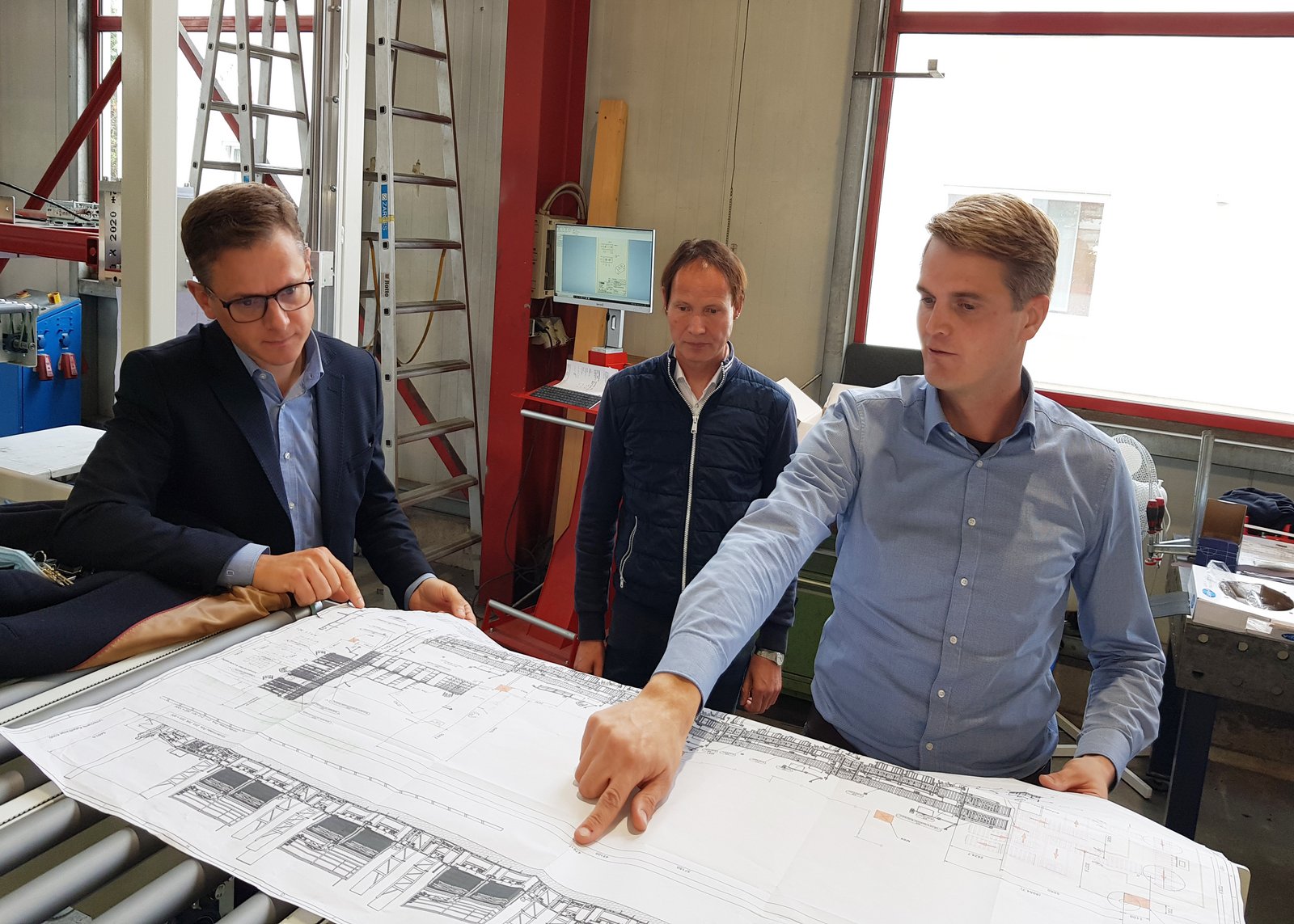 Benedikt Rotte veranschaulicht Carsten Linnemann eine Automatisation für einen großen Küchenhersteller aus OWL