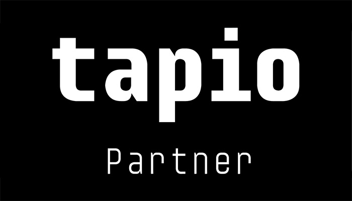 Weißer Schriftzug 'tapio' in moderner Schriftart mit dem Wort 'Partner' darunter auf schwarzem Hintergrund