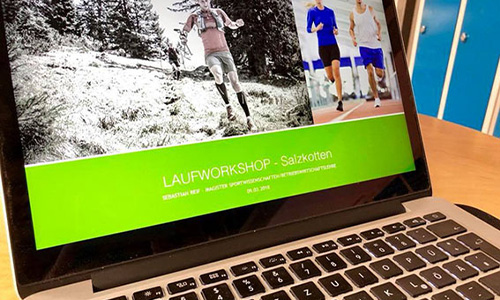 Laptop zeigt eine Webseite mit Bildern von Personen beim Laufen und die Überschrift Laufworkshop Saltzkotten auf grünem Hintergrund.