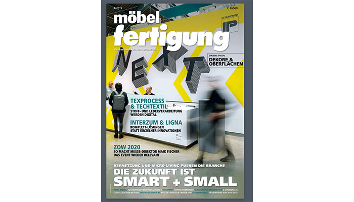 Titelblatt der Fachzeitschrift möbelfertigung mit dem Schwerpunkt auf vernetzte und kleine smarte Möbel, gezeigt mit einer Kunstinstallation und zwei unscharfen Personen im Vordergrund vor einer gelb-grauen Wand mit dem Schriftzug "NEXT".