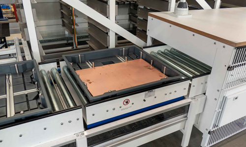 Industrielle Förderanlage mit Metallplatten auf Förderbändern in einer Fabrikumgebung