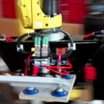 Nahaufnahme eines Industrieroboters mit Greifern und Saugnäpfen in einem Werkstatt- oder Produktionsumfeld