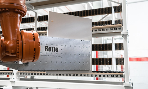 Nahaufnahme eines industriellen Roboters mit einem Metallteil, auf dem 