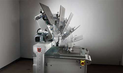 Industriemaschine mit beweglichem Arm, der verschiedene Positionen zeigt, in einem leeren Raum mit grauen Wänden