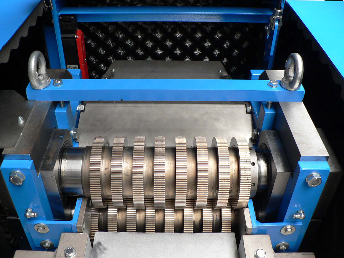 Nahaufnahme eines metallischen Zahnradmechanismus mit blauer Stahlrahmenumgebung in einer Maschine.